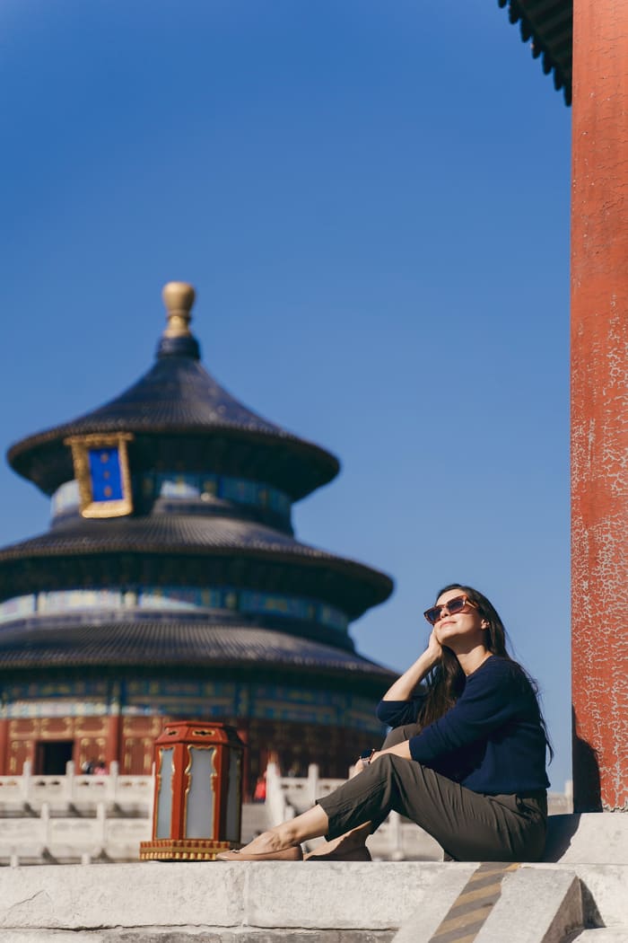 Una mujer tomandose una foto en una torre tradicional en Beijing, China